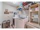 Bright laundry room with modern washer and dryer, storage shelves and bins for organized storage at 255 Sageglen Rd, Lawrenceville, GA 30044