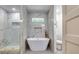 Stylish bathroom with marble walls and finishes, glass shower, standalone tub, and modern gold fixtures at 3244 Mount Olive Rd, Atlanta, GA 30344