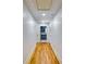 Hallway with wood floors leads to a laundry room with gray cabinets and white countertops at 3244 Mount Olive Rd, Atlanta, GA 30344