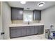 Laundry room with gray cabinets, white countertops, sink, and a window for natural light at 3244 Mount Olive Rd, Atlanta, GA 30344