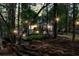 Backyard illuminated at dusk with ambient string lights highlighting the deck and surrounding trees at 4414 Aldenham Way, Suwanee, GA 30024