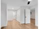 A bedroom with hardwood flooring and white walls leading to another room at 4414 Aldenham Way, Suwanee, GA 30024