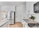 Bright kitchen features stainless steel appliances, granite counters, and white cabinets at 4414 Aldenham Way, Suwanee, GA 30024