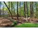 Lush backyard with mature trees, a small bridge, and a cozy hammock at 4414 Aldenham Way, Suwanee, GA 30024