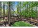 Lush backyard featuring a hammock and beautiful wooded views with a small footbridge at 4414 Aldenham Way, Suwanee, GA 30024