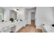 Bathroom with a vanity, white cabinets, a large mirror, and wood-look flooring, creating a bright and airy space at 4414 Aldenham Way, Suwanee, GA 30024