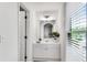 Bright bathroom with natural light, a white vanity, and an open doorway, creating a serene and functional space at 4414 Aldenham Way, Suwanee, GA 30024