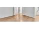Bright bedroom with wood-look flooring, white walls, and doorways to an en-suite bathroom and closet at 4414 Aldenham Way, Suwanee, GA 30024