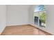 Bright bedroom with a large arched window and light wood flooring at 4414 Aldenham Way, Suwanee, GA 30024