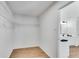 Walk-in closet with wood-look flooring and wire shelving with an adjoining bathroom, maximizing space and functionality at 4414 Aldenham Way, Suwanee, GA 30024