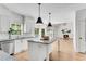 Bright kitchen with stainless appliances, island, and an open-concept layout to the living room at 4414 Aldenham Way, Suwanee, GA 30024