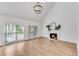 Cozy living room with a fireplace, large windows, and light wood flooring at 4414 Aldenham Way, Suwanee, GA 30024