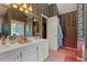 Full bathroom showcasing floral wallpaper, a double sink vanity, and an open door at 4531 Cedar Dr, Loganville, GA 30052