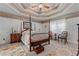 Lovely bedroom showcasing a four-poster bed, neutral wall colors, and a tray ceiling with floral border at 4531 Cedar Dr, Loganville, GA 30052