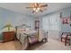 Inviting bedroom featuring a metal bed, floral bedding, and a window with a floral curtain at 4531 Cedar Dr, Loganville, GA 30052