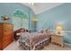 Cozy bedroom featuring a floral bedspread, natural light, and a decorative stained-glass window at 4531 Cedar Dr, Loganville, GA 30052