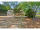 Two-story home with light-blue siding, red shutters, and a sprawling front yard with mature trees at 4531 Cedar Dr, Loganville, GA 30052