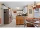 Well-lit kitchen with white cabinets, stainless steel refrigerator, and eat-in dining area at 4531 Cedar Dr, Loganville, GA 30052