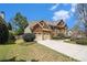 Charming brick home featuring an attached two-car garage, beautiful landscaping, and a spacious driveway at 5222 Camden Lake Nw Pkwy, Acworth, GA 30101
