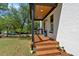 Charming covered front porch featuring wood flooring, steps, and a white brick foundation at 917 Derrydown Way, Decatur, GA 30030