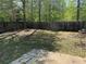 Fenced backyard featuring a patio, mature tree, and shaded lawn at 2575 Rosehill Circle, Lithia Springs, GA 30122