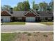 A well-maintained brick townhouse featuring a garage, small yard, and a shared driveway at 2575 Rosehill Circle, Lithia Springs, GA 30122