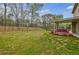 Spacious backyard with a well-maintained lawn, a cozy porch swing, and a wooden fence for privacy at 8045 Hillside Climb Way, Snellville, GA 30039