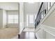 Bright foyer featuring hardwood floors, staircase, and a view into a carpeted living space at 8045 Hillside Climb Way, Snellville, GA 30039