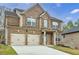 Handsome two-story brick home featuring a two-car garage, manicured lawn and covered porch at 8045 Hillside Climb Way, Snellville, GA 30039