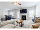 Cozy living room with a fireplace, ceiling fan, and a comfortable sofa set, perfect for relaxation and entertainment at 8045 Hillside Climb Way, Snellville, GA 30039