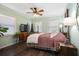 A cozy bedroom features wood floors, a ceiling fan, and two windows for plenty of light at 1384 Windburn Dr, Marietta, GA 30066