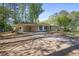 Ranch-style home with a covered carport and an extensive driveway amid a wooded landscape at 1384 Windburn Dr, Marietta, GA 30066
