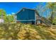 Well-maintained backyard of the house with blue siding and green forest at 166 Rustin Dr, Dallas, GA 30157