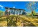 View of backyard with wooden deck, lawn, and mature trees against a bright sky at 166 Rustin Dr, Dallas, GA 30157