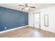 Bedroom featuring hardwood floors, a ceiling fan, blue accent wall and a large window at 166 Rustin Dr, Dallas, GA 30157