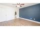 Spacious bedroom with a ceiling fan, blue accent wall and hardwood floors at 166 Rustin Dr, Dallas, GA 30157