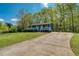 Inviting one-story home with a lovely front porch, surrounded by a lush green lawn and mature trees, plus long driveway at 166 Rustin Dr, Dallas, GA 30157