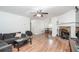 Spacious living room featuring wood floors, fireplace, a ceiling fan, and lots of natural light from the window at 166 Rustin Dr, Dallas, GA 30157