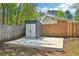 Backyard featuring a modern storage shed on a concrete slab with a surrounding lawn at 1900 Foster Trace Ct, Lawrenceville, GA 30043