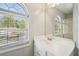 Bathroom with a wide single sink vanity under an arched window and a large mirror at 1900 Foster Trace Ct, Lawrenceville, GA 30043