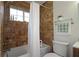 Bathroom with tiled walls, shower with curtain, and a plant on a glass shelf at 311 Peachtree Hills Ne Ave # 17C, Atlanta, GA 30305
