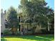 Brick condo building with charming balconies, lush landscaping, and well-maintained lawn on a sunny day at 311 Peachtree Hills Ne Ave # 17C, Atlanta, GA 30305