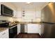 Well-lit kitchen features stainless steel appliances, granite countertops, and white cabinets at 311 Peachtree Hills Ne Ave # 17C, Atlanta, GA 30305