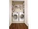 Organized laundry closet features a side-by-side washer and dryer, wood look floors and wire shelving at 311 Peachtree Hills Ne Ave # 17C, Atlanta, GA 30305