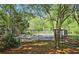 Fenced community pool surrounded by trees, grass and a pool house at 311 Peachtree Hills Ne Ave # 17C, Atlanta, GA 30305