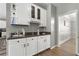 Stylish bar area with white cabinets, granite countertops, and shelving at 3889 Elm Trace Dr, Loganville, GA 30052