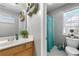 Bright bathroom featuring a framed mirror, single sink vanity and toilet with a shower behind a curtain at 3889 Elm Trace Dr, Loganville, GA 30052