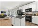 Open kitchen with white cabinets, granite countertops, stainless steel refrigerator, and island at 3889 Elm Trace Dr, Loganville, GA 30052