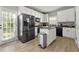 Modern kitchen with stainless steel appliances, white cabinets, and an island at 3889 Elm Trace Dr, Loganville, GA 30052
