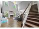 Bright living room with fireplace, hardwood floors, large windows, and staircase at 3889 Elm Trace Dr, Loganville, GA 30052